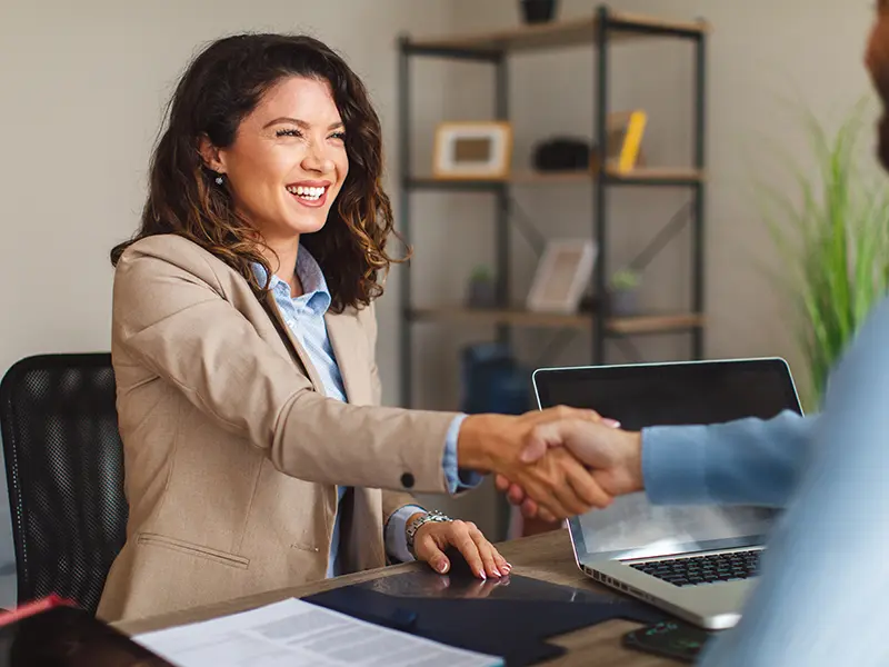 smiling business woman shaking someones hand